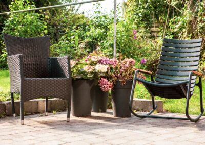 Terrasse med blomster og havemøbler ved HabitusHuset Holbo.