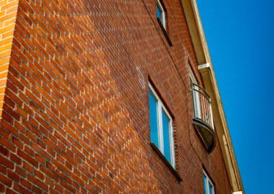 Nærbillede af murværk og vinduer på HabitusHuset Holbo.